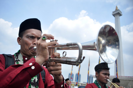 Jakarta, Indonesia - Augusst 31, 2013 : One of the tanjidor musicians blows a trumpet at the cultural carnival event in Jakarta - Indonesiaのeditorial素材
