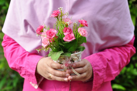 Holding plastic flower arrangements of various colors in pots selective focusの写真素材
