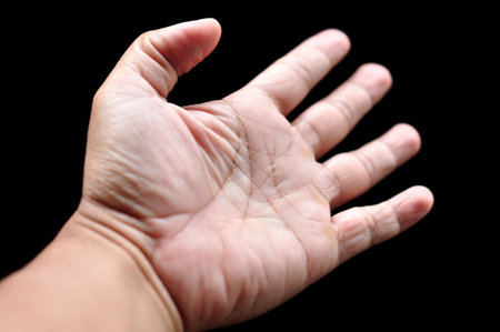 Asian man palms wide open fingers black backgroundの写真素材