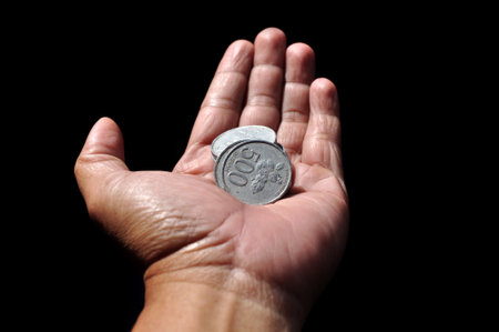 Coins on the palm of the hand on a black backgroundの写真素材