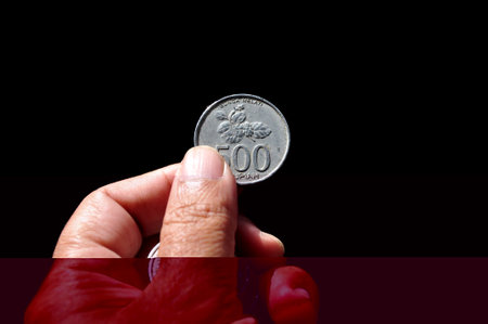 Holding indonesian coin money black background