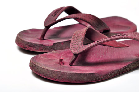 Worn and ugly flip flops on white backgroundの写真素材