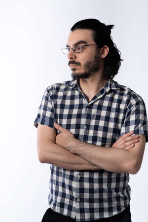 Portrait of young man with glasses using smartphone on white background.