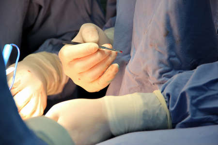 Close-up of the hands and tools of the doctors.