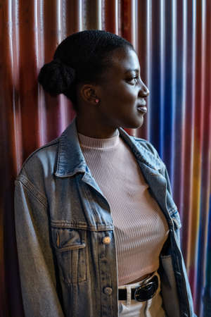 Happy black young woman taking selfie on smartphone on colorful background