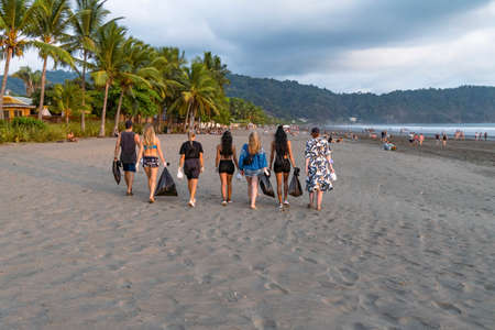 Team of vigorous recycling volunteers collecting plastic rubbish into bags. Save the planet.の写真素材