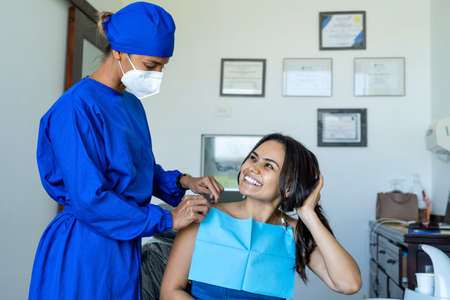 Young male patient visiting dentist office. Short Hair man with healthy straight white teeth sitting at dental chair and waiting his doctor. Dental clinic background for copy space text.の写真素材