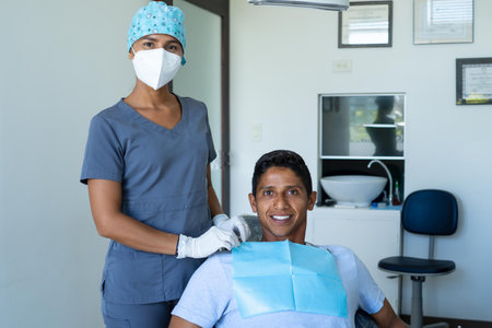 Portrait of happy male patient and pretty young female dentist looking at camera. Concept of whitening, dental care, oral health, dentistry advertising.の写真素材