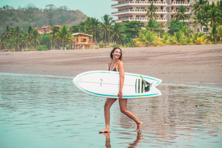 Beautiful young latin woman with surfboard. Holiday and summer concept.