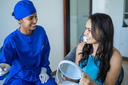 Female dentist talking to her patient at dentist's office.の写真素材