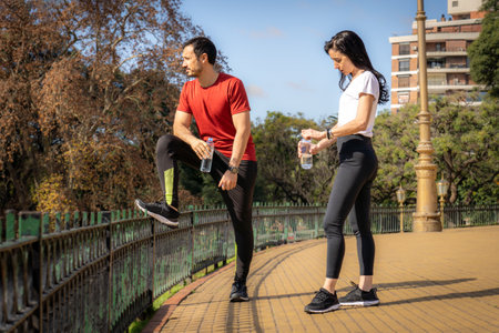 Fitness latin athlete and white woman resting taking a break after workout.の写真素材