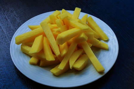 Sliced potatoes on a porcelain plate ready to fryの写真素材