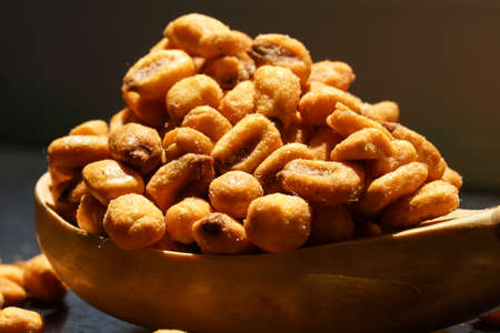 crispy fried corn kernels on a wooden spoonの写真素材