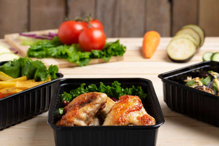 three black containers on rustic table, blurred background