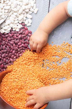 White and red beans with ginger lentils in bowls, kids hands