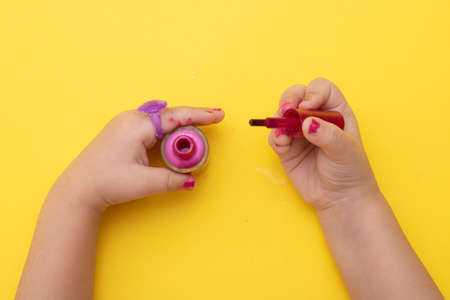 Kid applying pink nail polish, kids cosmetics. Top viewの写真素材