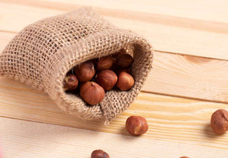 Hazelnut in small sackcloth on wooden table, selective focus. Zero waste conceptの写真素材