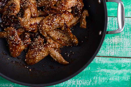 Closeup of a thai recipe with caramelized chicken wings in a wok, top viewの写真素材