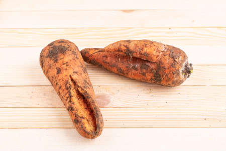 Ugly carrots on wooden table, top viewの写真素材