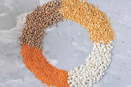 A mixture of legumes and lentils in circle, beans background, place for text food. Flat lay