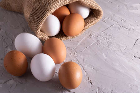 Chicken white and brown eggs in sackcloth on table. Eco bag, zero waste
