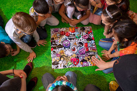 Children friends sitting in a circle and playing table game on floor, flat layのeditorial素材