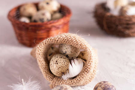 quail eggs in eco burlap sack on grey, nest backgroundの写真素材