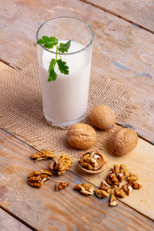 glass of milk with walnuts and mint leaf, vertical. Ketoの写真素材