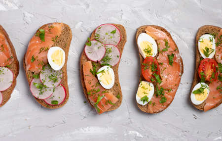 colorful sandwiches on grey background from above - flat lay composition.の写真素材