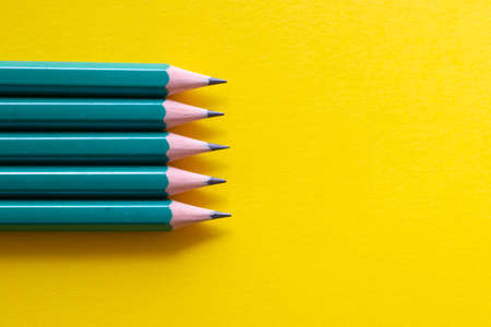 Set of black pencils on yellow background, view aboveの写真素材