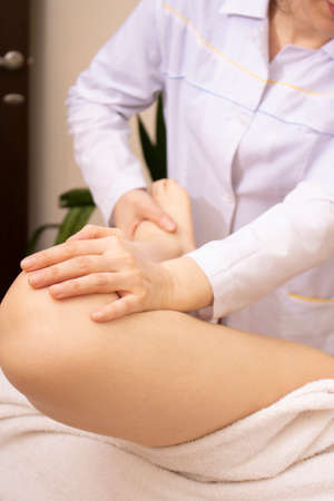 Making leg massage in spa salon, verticalの写真素材