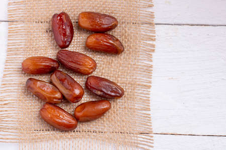 Juicy dates fruit zero waste sackcloth, wooden table. View above, nobody