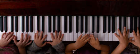 Kids hands playing on the piano, online education