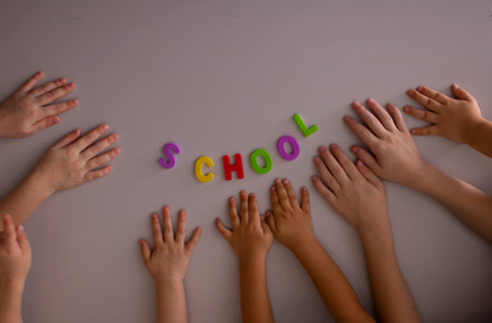 Kids hands and letters on gray chalkboard. Top view and place for textの写真素材