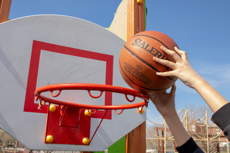 hands reaching up to make a shot at basketball hoop