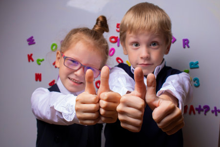 Pupils raise thumbs up, kids are ready to schoolの写真素材