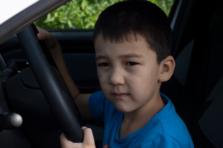 Cute little driver driving a luxury car