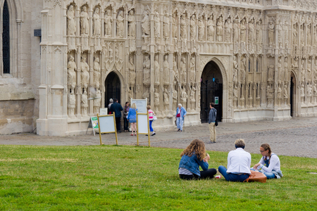 EXETER, UK, 11 July 2016: People sit on the lawn near the walls of the cathedral in Exeter. Devon. Englandのeditorial素材