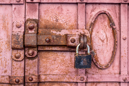 Lock with a latch on an old metal door in redの写真素材