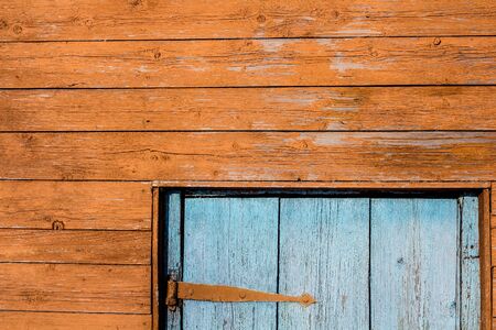 fragment of a wooden house. Orange wall and blue door.の写真素材