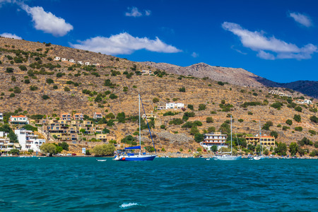 Coast in the village of Elounda. Mirabello Bay. View to the beach from the sea. Several small sailing ships.の写真素材