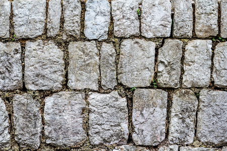 Background of gray stones. A fragment of an old wall or a fence.の写真素材