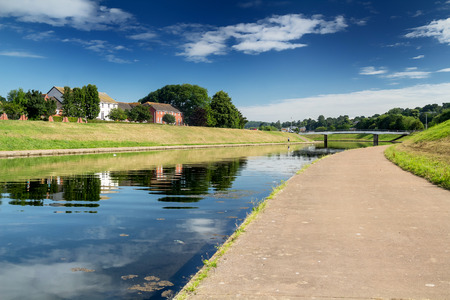 View of the Exe River Canal in Exeter. Sunny calm morning. You can see a car bridge through the canal. Exeter. Devon. Englandの写真素材