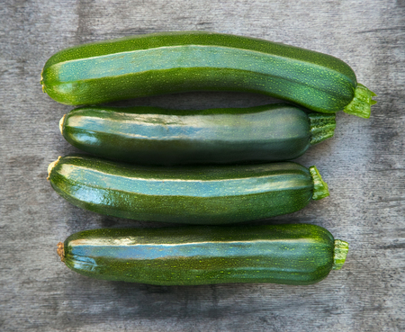 Four fresh zucchini green. On a wooden gray background. View from aboveの写真素材