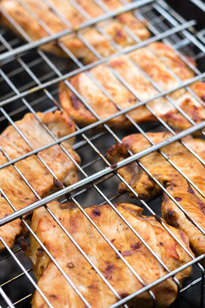 Pieces of turkey are cooked in the grill on the coalsの写真素材