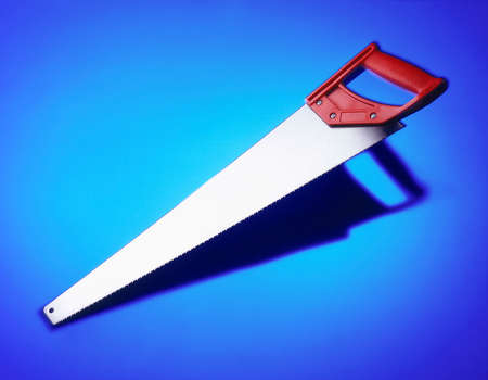 WOOD SAW ON BLUE BACKGROUNDの写真素材