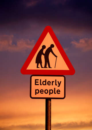 ELDERLY PEOPLE ROAD TRAFFIC SIGN AGAINST TWILIGHT SKYの写真素材