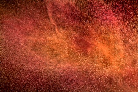 Red and orange particles swirling in turbulent airの写真素材