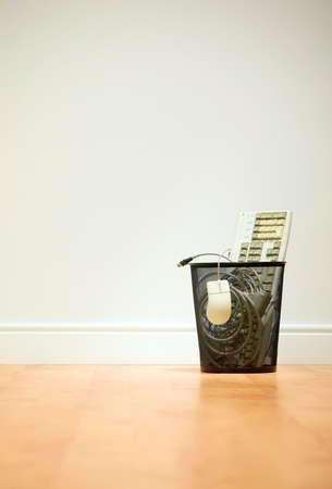 Litter bin full of scrap computer equipment on wooden floorの写真素材