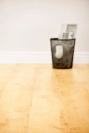 Litter bin full of scrap computer equipment on wooden floorの写真素材